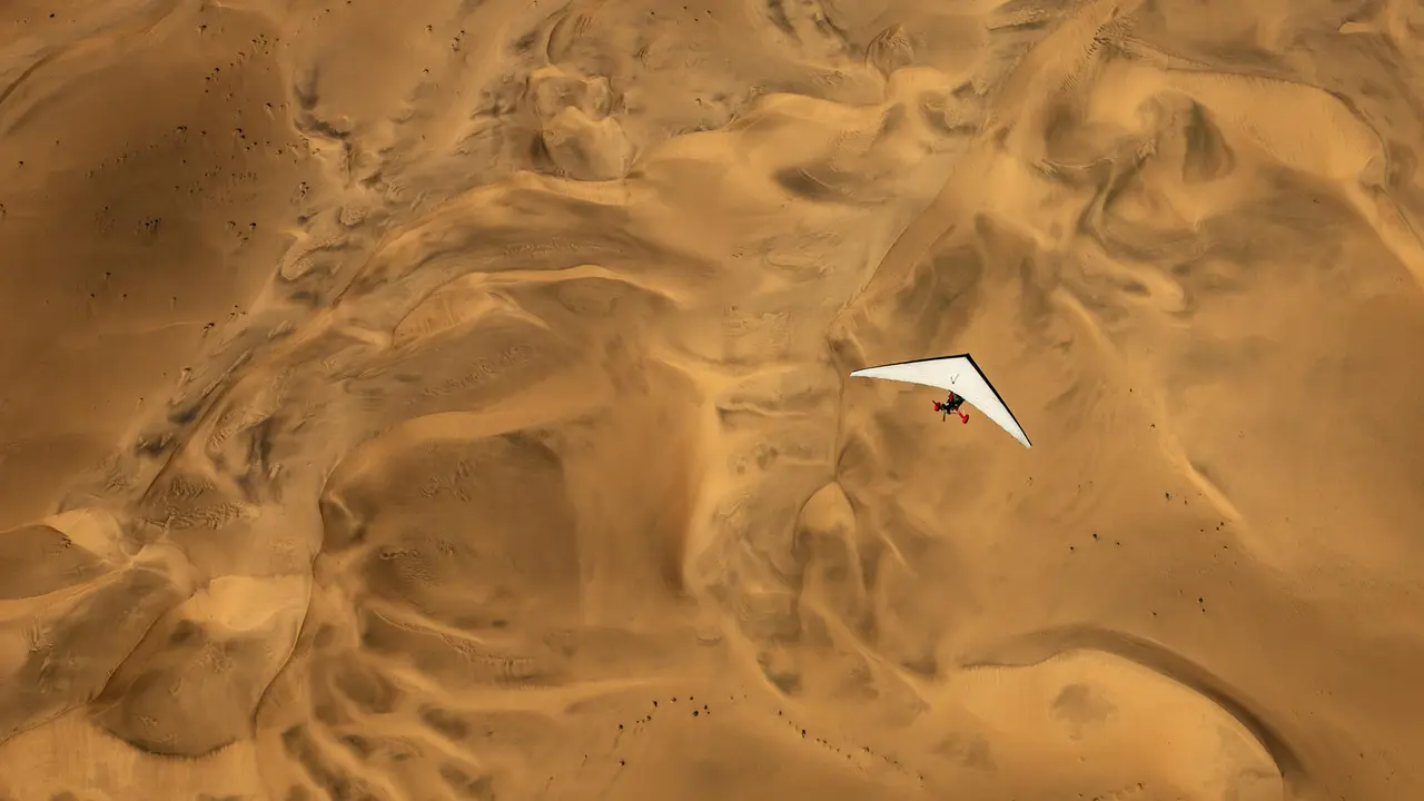 An ultralight aircraft flying over the sands of Namibia