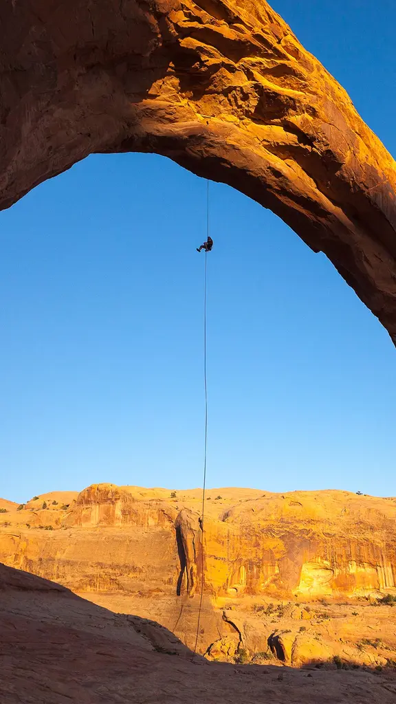 A man rappels off Corona Arch near Moab, Utah, United States
